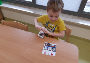 Chłopiec układa puzzle z karetką pogotowia